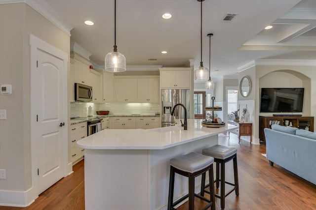 kitchen with a breakfast bar, pendant lighting, stainless steel appliances, and a large island