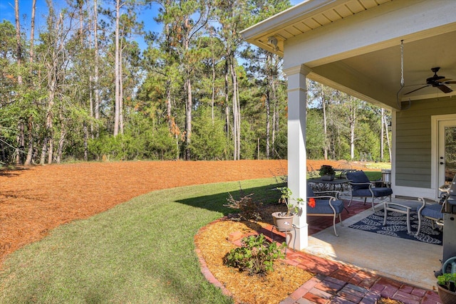 view of yard featuring ceiling fan and a patio