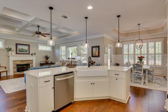 kitchen with a kitchen island with sink, coffered ceiling, white cabinets, sink, and stainless steel dishwasher