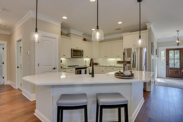 kitchen with white cabinetry, a large island, dark hardwood / wood-style floors, decorative light fixtures, and appliances with stainless steel finishes