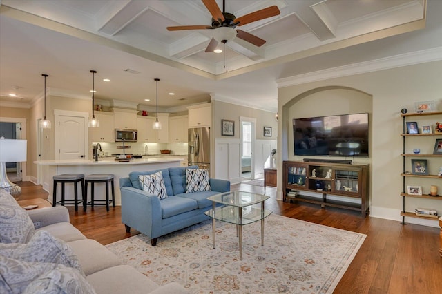 living room featuring ceiling fan, beam ceiling, crown molding, and coffered ceiling