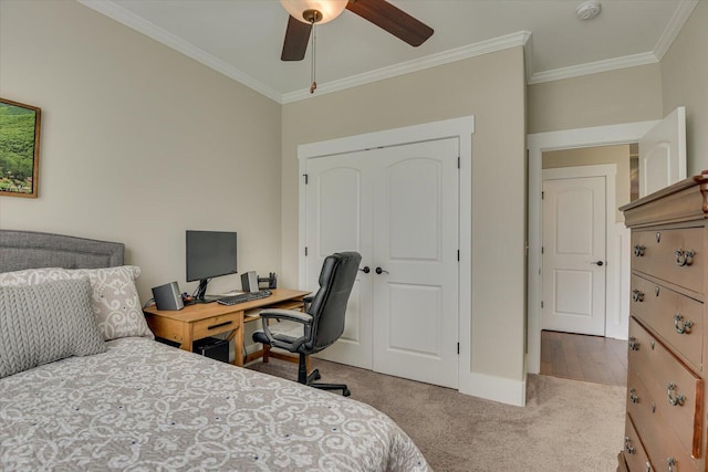 carpeted bedroom featuring ceiling fan, a closet, and ornamental molding