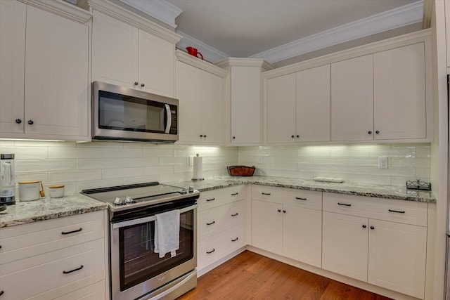 kitchen featuring backsplash, white cabinetry, and appliances with stainless steel finishes