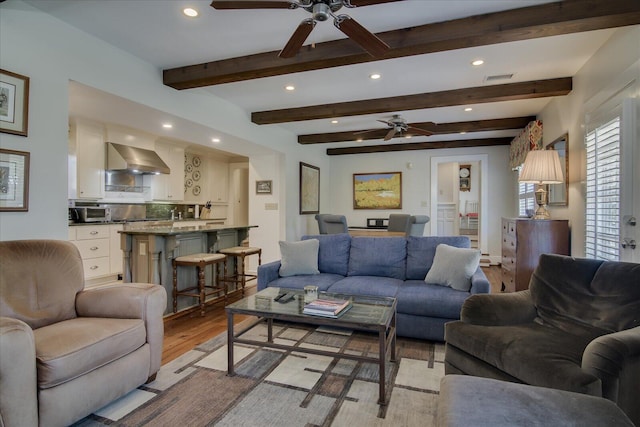 living room with beam ceiling and light hardwood / wood-style floors