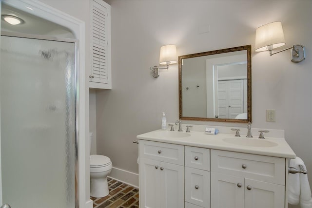 bathroom featuring vanity, toilet, and a shower with shower door