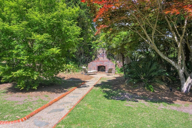 view of yard featuring an outdoor brick fireplace