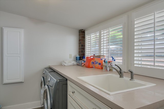 laundry room with cabinets, independent washer and dryer, and sink