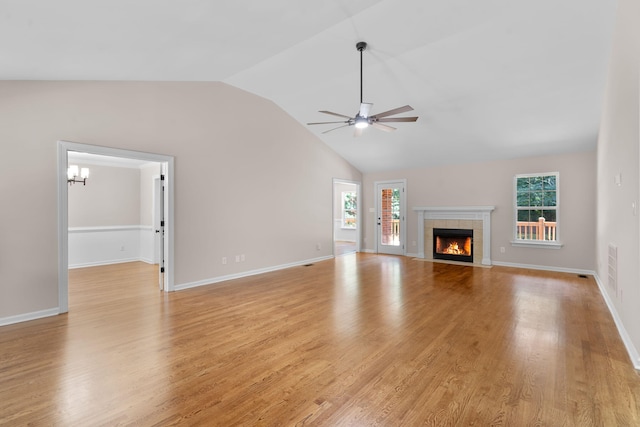 4200 Waters Edge Ln, Appling, GA 30802 - unfurnished living room featuring a ceiling fan, lofted ceiling, light wood-style floors, a tile fireplace, and a chandelier