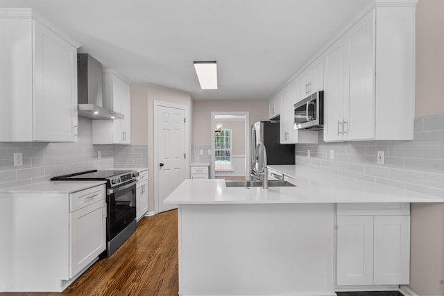 4200 Waters Edge Ln, Appling, GA 30802 - kitchen with appliances with stainless steel finishes, wall chimney range hood, a peninsula, light countertops, and dark wood-style floors