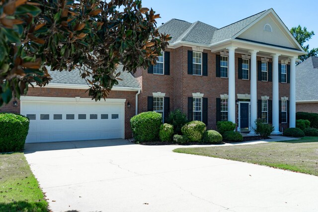 724 Avrett Cir, Evans, GA 30809 - neoclassical / greek revival house featuring driveway, brick siding, an attached garage, and a shingled roof
