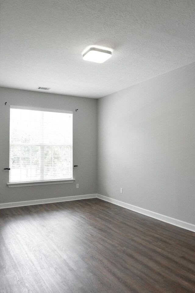 724 Avrett Cir, Evans, GA 30809 - spare room with dark wood finished floors, baseboards, and a textured ceiling