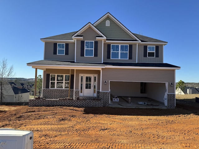 view of front of property featuring covered porch and a garage