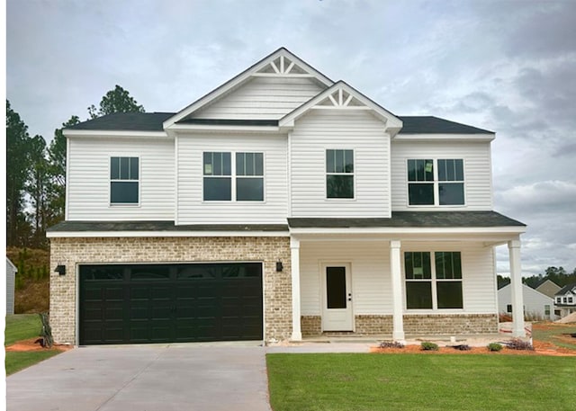 craftsman-style house with brick siding, an attached garage, a front yard, covered porch, and driveway