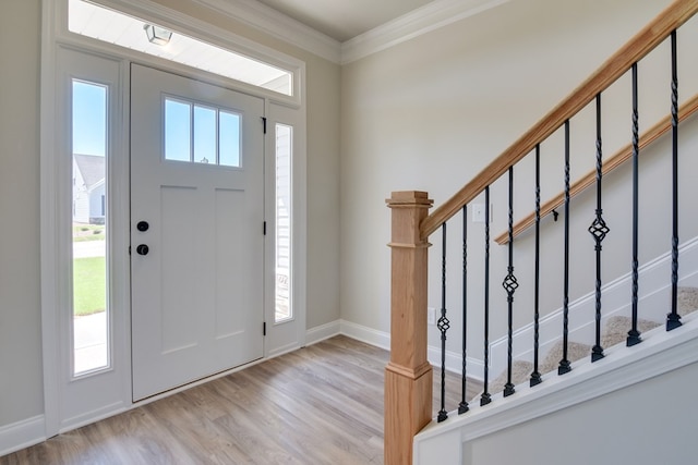 entryway with crown molding, stairway, wood finished floors, and baseboards