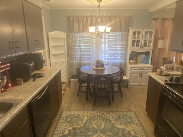 kitchen featuring ornamental molding, black appliances, light hardwood / wood-style flooring, an inviting chandelier, and hanging light fixtures