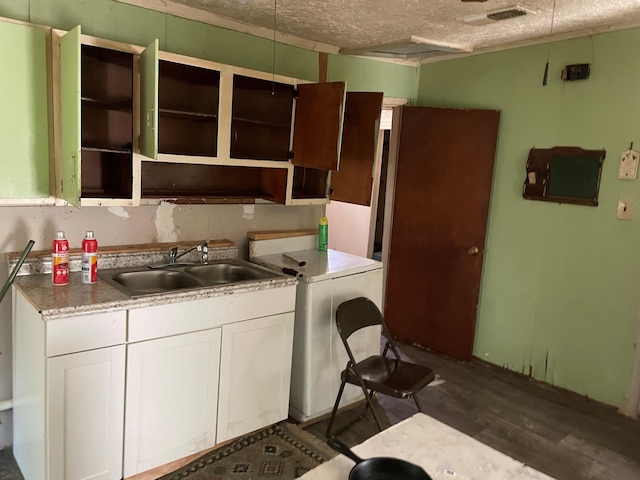 1466 Swanee Quintet Blvd, Augusta, GA 30901 - kitchen with open shelves, dark wood-type flooring, a textured ceiling, washer / dryer, and white cabinetry