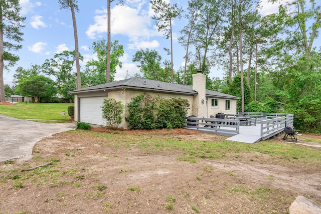 1715 Deerwood Dr, Augusta, GA 30906 - rear view of property with concrete driveway, an attached garage, a chimney, a deck, and brick siding