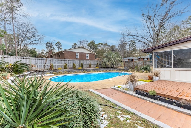 view of swimming pool with a wooden deck and a diving board