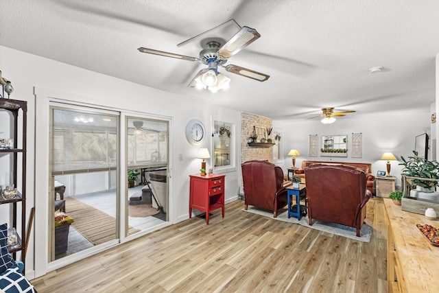 interior space with ceiling fan, plenty of natural light, a textured ceiling, and light hardwood / wood-style floors