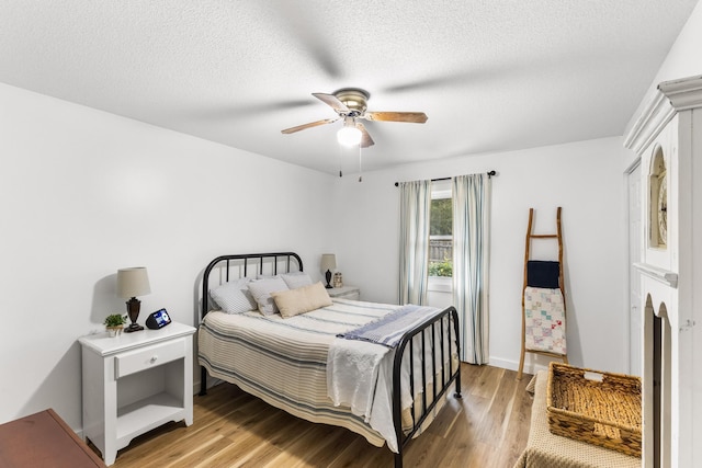 bedroom with a textured ceiling, ceiling fan, and light wood-type flooring