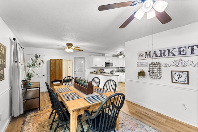 dining space featuring a textured ceiling and light wood-type flooring