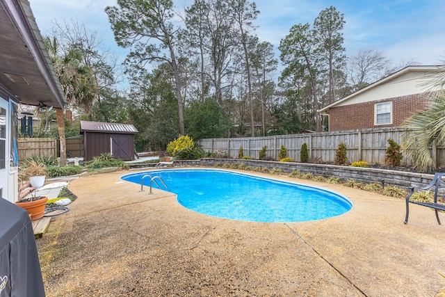 view of swimming pool with a storage shed and a patio area