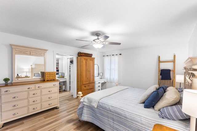 bedroom featuring ceiling fan, light hardwood / wood-style floors, and a textured ceiling