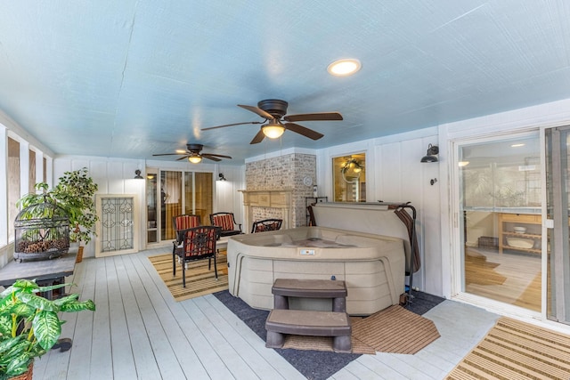 wooden terrace featuring ceiling fan and a stone fireplace