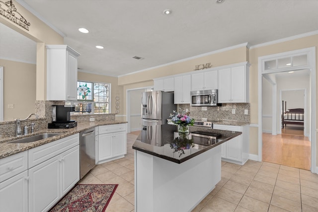 kitchen featuring light tile patterned floors, stainless steel appliances, visible vents, white cabinets, and a sink