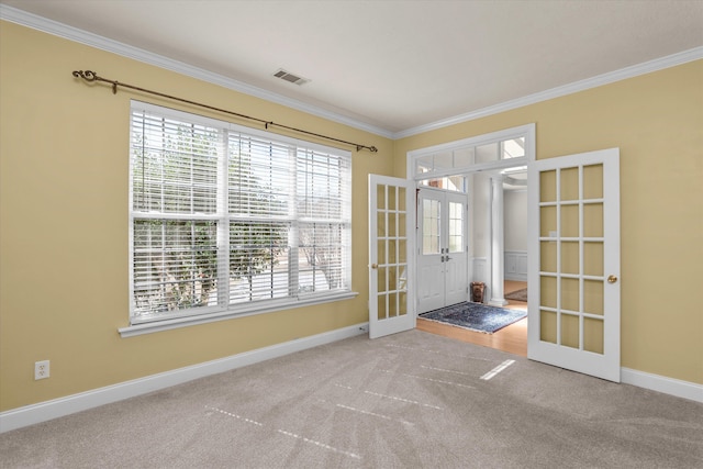 entryway with carpet floors, visible vents, baseboards, ornamental molding, and french doors