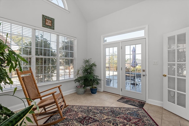 entryway with vaulted ceiling, baseboards, and tile patterned floors