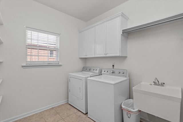 laundry room featuring light tile patterned floors, washing machine and dryer, a sink, baseboards, and cabinet space