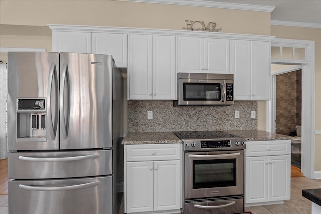 kitchen featuring appliances with stainless steel finishes, white cabinets, crown molding, and tasteful backsplash