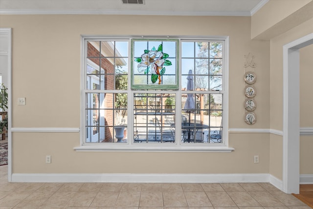 interior space with ornamental molding, visible vents, and baseboards