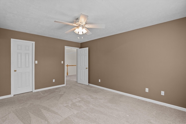 unfurnished bedroom with light carpet, baseboards, and a textured ceiling