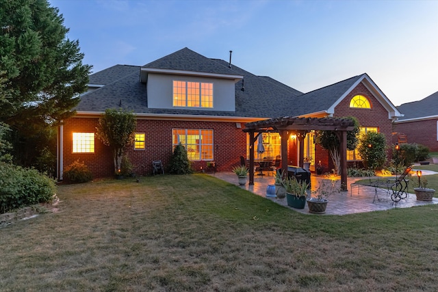 back of house featuring brick siding, a yard, a patio, and a pergola