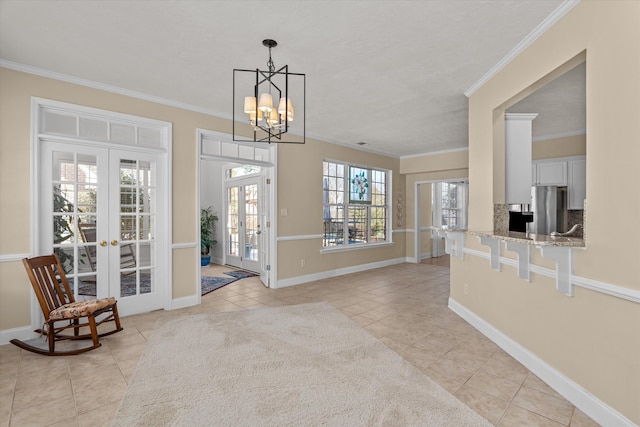 foyer with french doors, light tile patterned flooring, crown molding, and baseboards