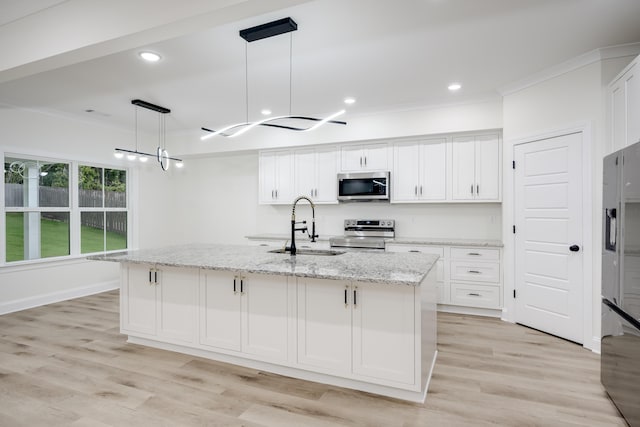 3909 Lakeside Pass, Hephzibah, GA 30815 - kitchen featuring appliances with stainless steel finishes, a sink, crown molding, white cabinetry, and an island with sink
