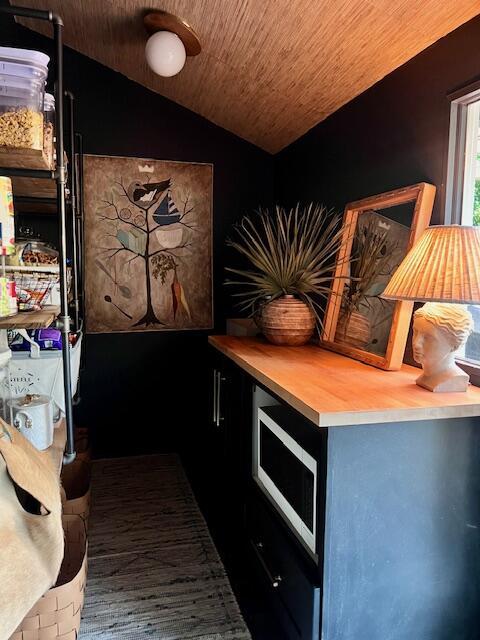 kitchen featuring stainless steel microwave, wood ceiling, light countertops, and lofted ceiling