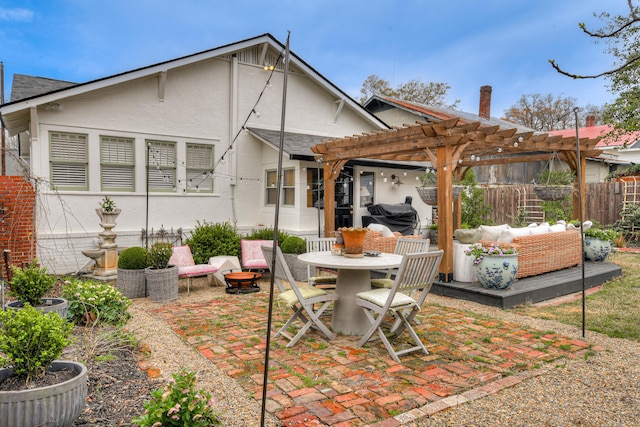 rear view of house with outdoor dining space, a patio, fence, a pergola, and stucco siding