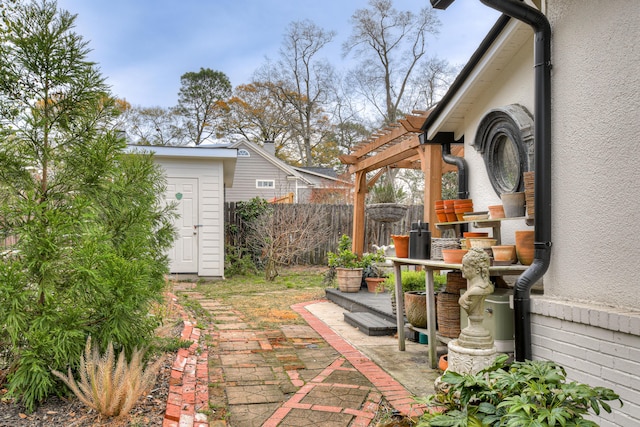 view of yard with a storage unit, a patio, an outbuilding, and fence