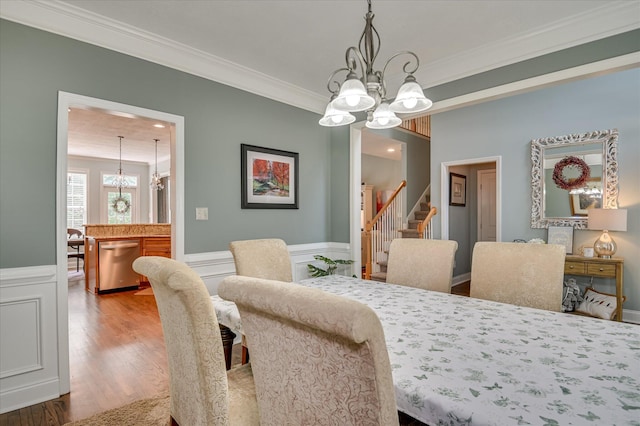 1076 Conn Dr, Evans, GA 30809 - dining area featuring a chandelier, crown molding, stairway, wood finished floors, and wainscoting