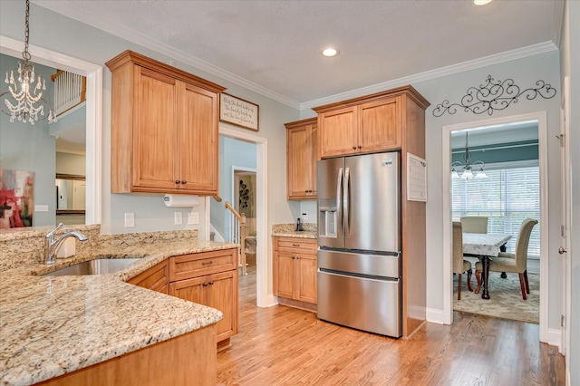 1076 Conn Dr, Evans, GA 30809 - kitchen with stainless steel refrigerator with ice dispenser, a chandelier, a sink, light wood-style floors, and light stone counters