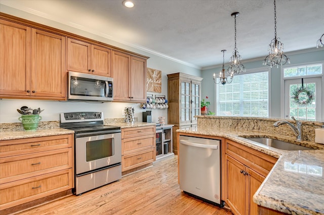 1076 Conn Dr, Evans, GA 30809 - kitchen featuring appliances with stainless steel finishes, a sink, ornamental molding, a chandelier, and light wood-type flooring