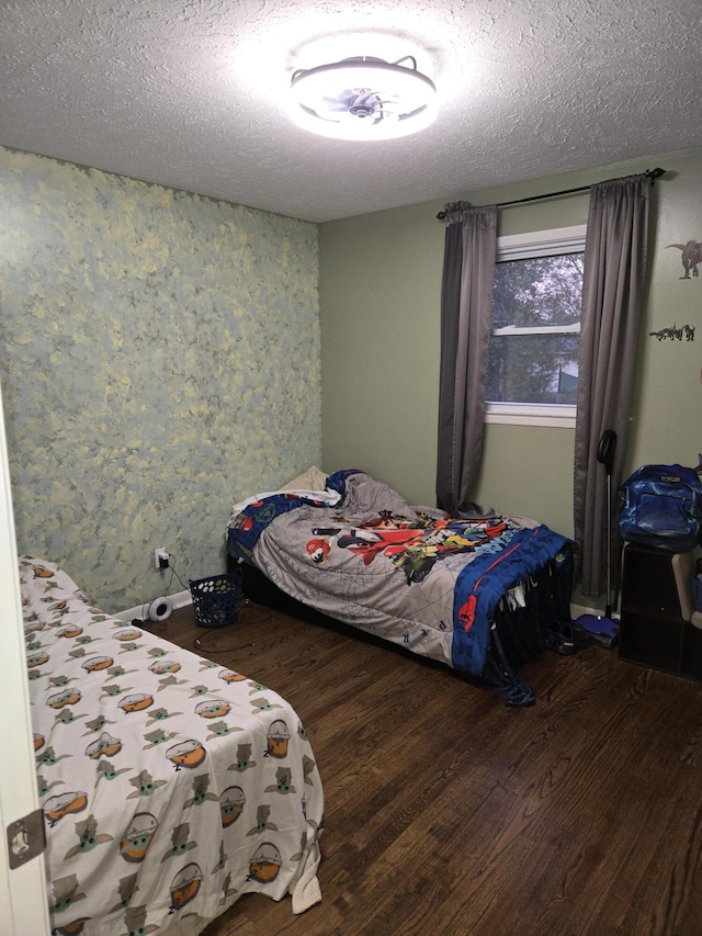 bedroom with a textured ceiling and wood finished floors