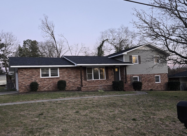 split level home with brick siding and a front yard