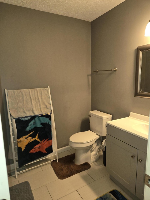 bathroom featuring toilet, a textured ceiling, and vanity