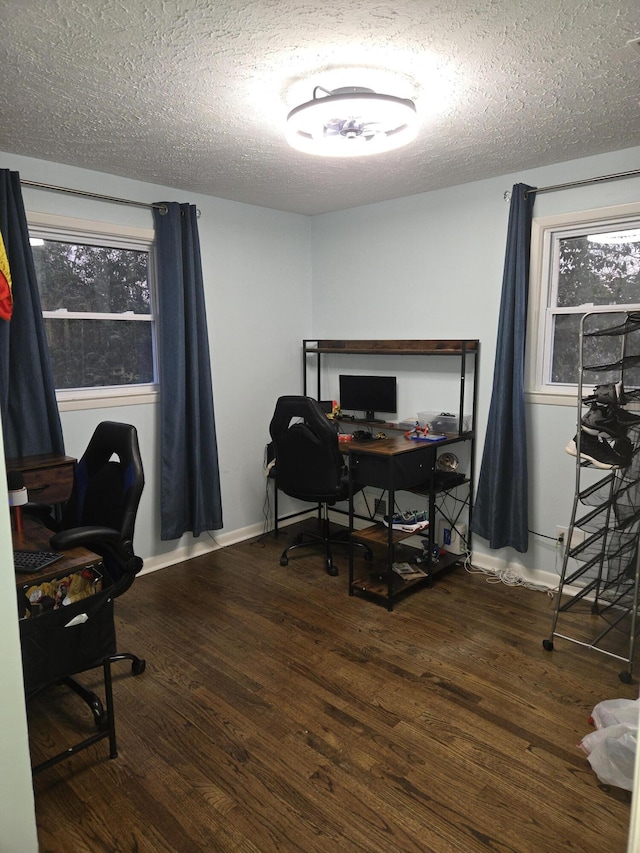 office featuring a textured ceiling, dark wood-type flooring, and baseboards