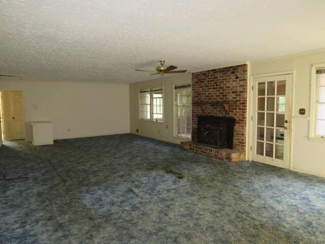 4629 Silver Lake Dr, Evans, GA 30809 - unfurnished living room featuring a fireplace, carpet, a textured ceiling, and a ceiling fan