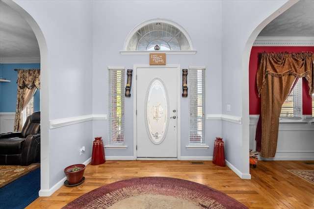 foyer featuring ornamental molding and hardwood / wood-style floors